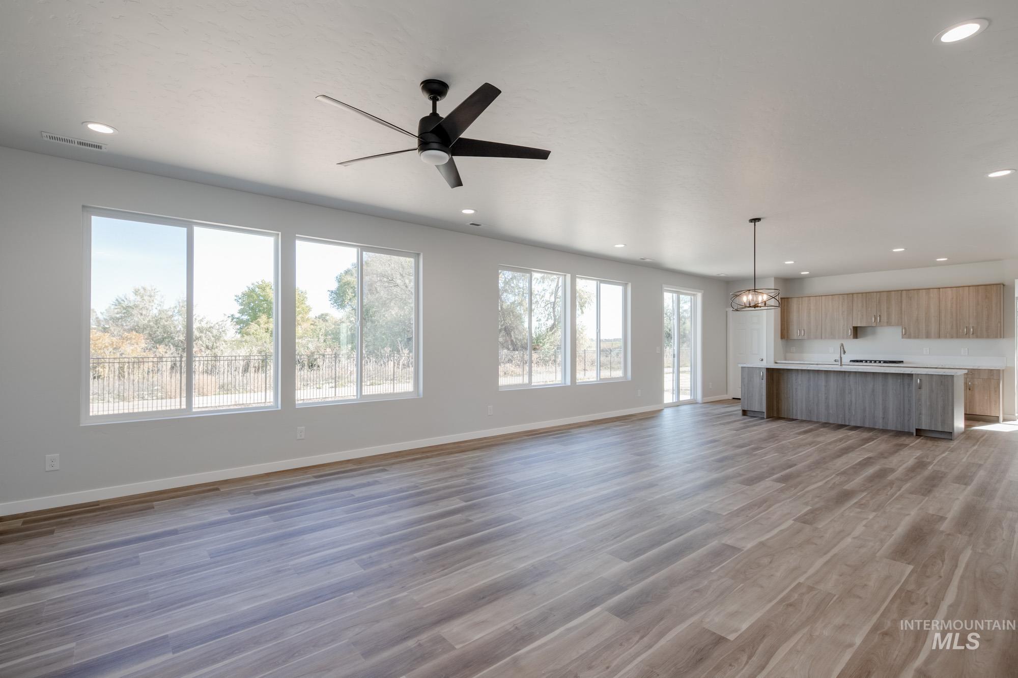 3170 South Maple Rnch Way Nampa, ID 83686 - Photo 12 of 32 Unfurnished living room featuring recessed lighting, dark wood-type flooring, ceiling fan, and a chandelier
