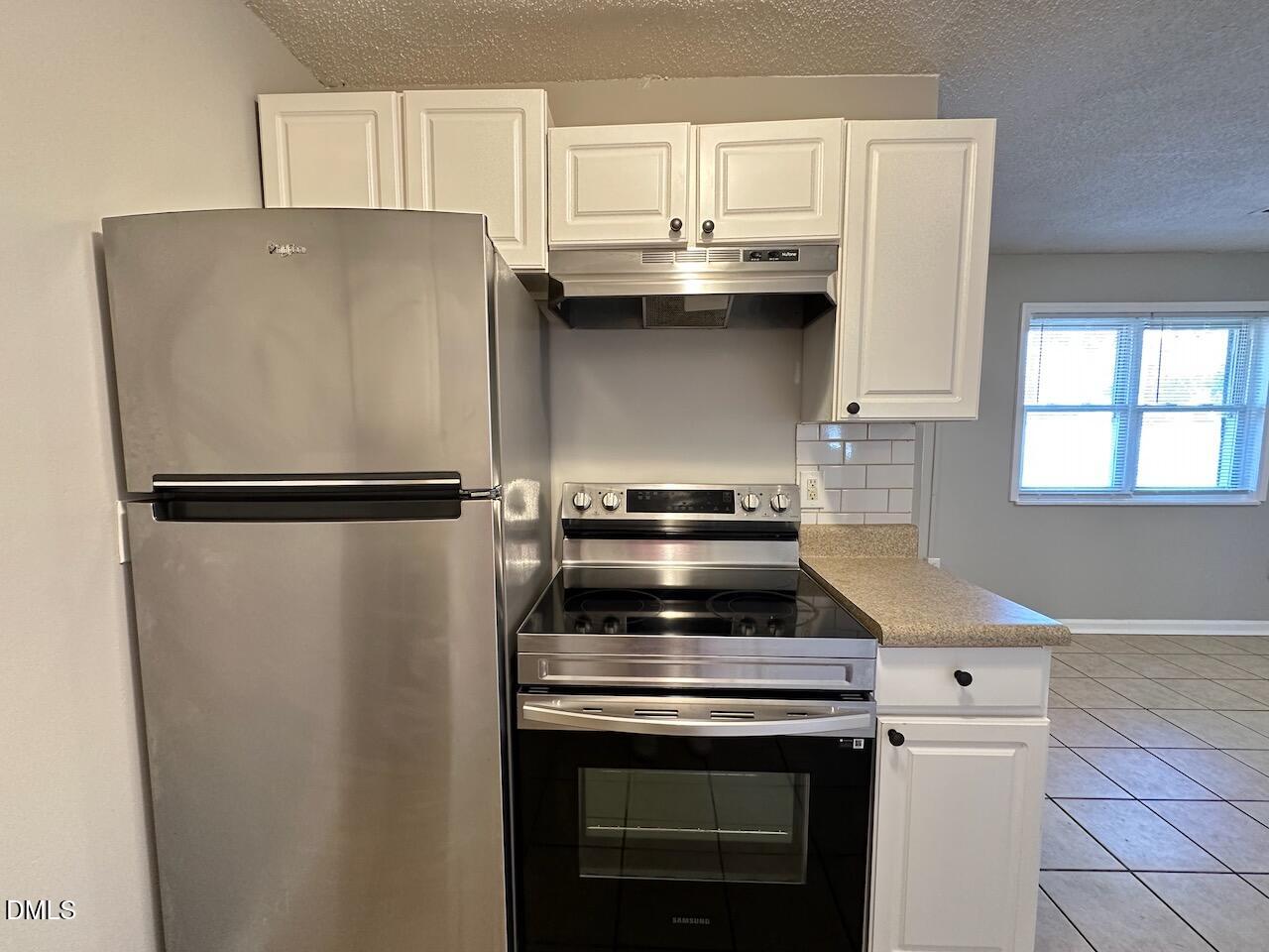 1128 Savannah Drive Raleigh, NC 27610 - Photo 6 of 21 a kitchen with stainless steel appliances a refrigerator and a stove