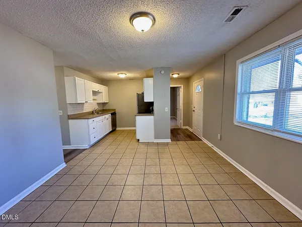a large white kitchen with a stove a sink dishwasher and a refrigerator