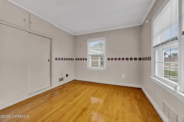 a view of a room with wooden floor and a window