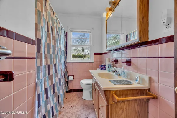 a bathroom with a sink a toilet and shower curtain