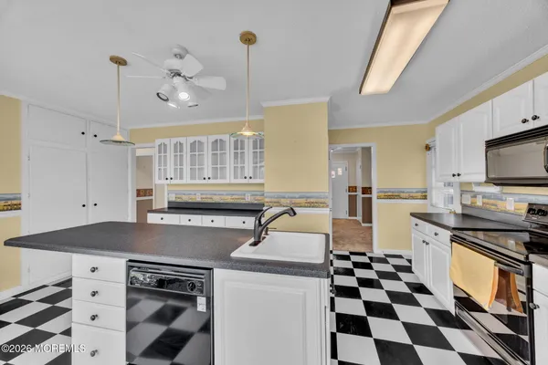 a kitchen with a sink a stove and cabinets