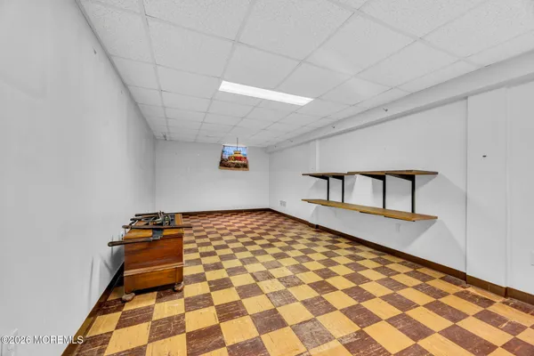 a bedroom with a bed and a black white checkered floor
