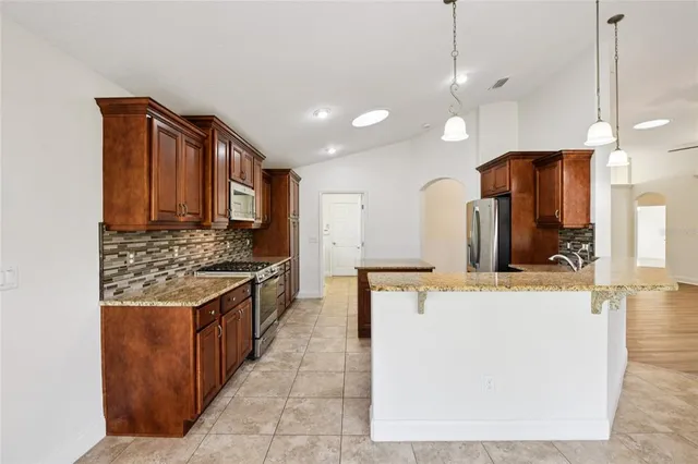 a kitchen with stainless steel appliances granite countertop a stove and a refrigerator
