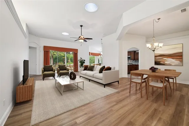 a living room with furniture or chandelier and a wooden floor