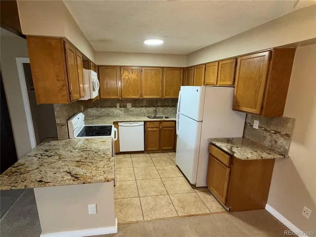 a kitchen with a refrigerator sink stove and wooden cabinets