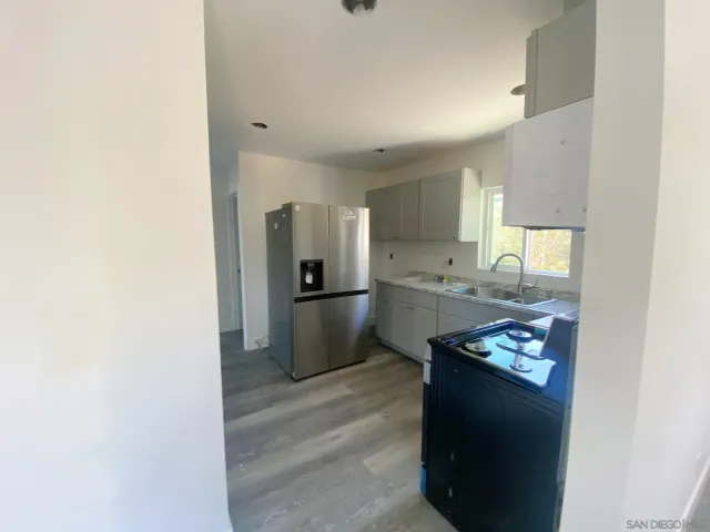 a kitchen with stainless steel appliances granite countertop a refrigerator and a sink