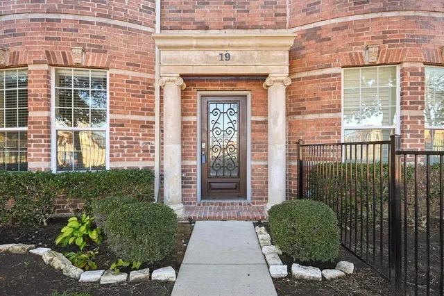 a view of a brick house with potted plants