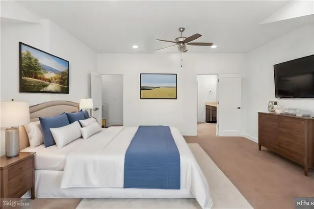 a bedroom with a large bed and a flat screen tv