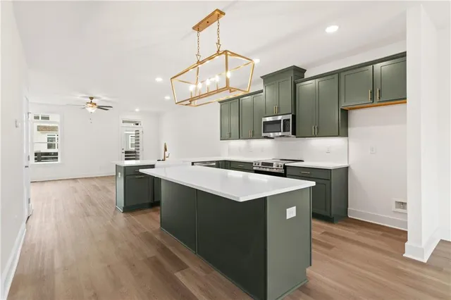 a kitchen with stainless steel appliances granite countertop a sink a stove and a wooden floors