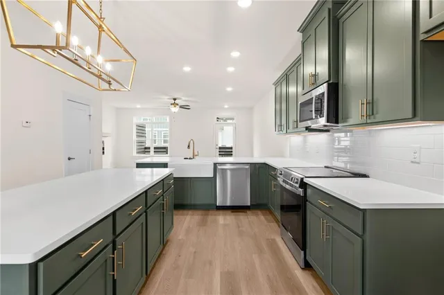 a kitchen with stainless steel appliances granite countertop a sink a stove and a refrigerator