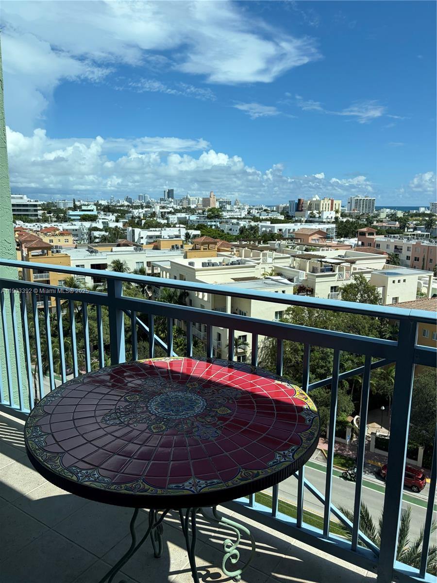 90 Alton Road, Unit 1007 Miami Beach, FL 33139 - Photo 11 of 16 a view of a balcony with table and chairs