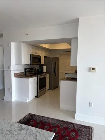 a kitchen with a sink and white cabinets