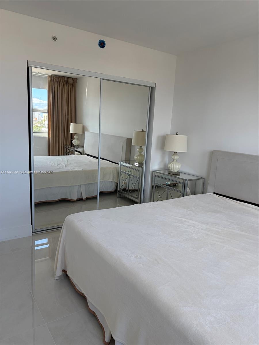 90 Alton Road, Unit 1007 Miami Beach, FL 33139 - Photo 15 of 16 a bedroom with a bed and a large window