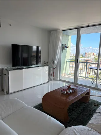 a living room with a bed furniture and a flat screen tv