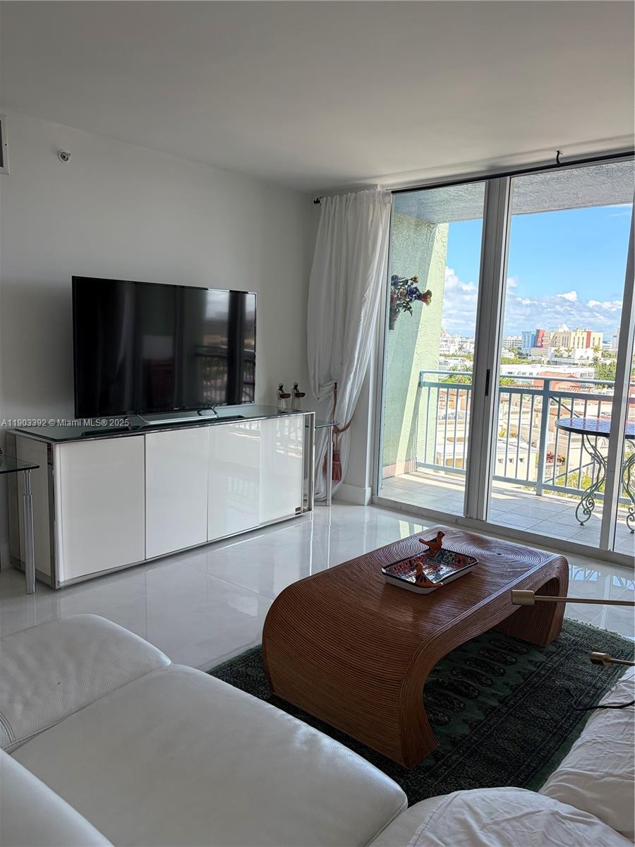 90 Alton Road, Unit 1007 Miami Beach, FL 33139 - Photo 3 of 16 a living room with a bed furniture and a flat screen tv