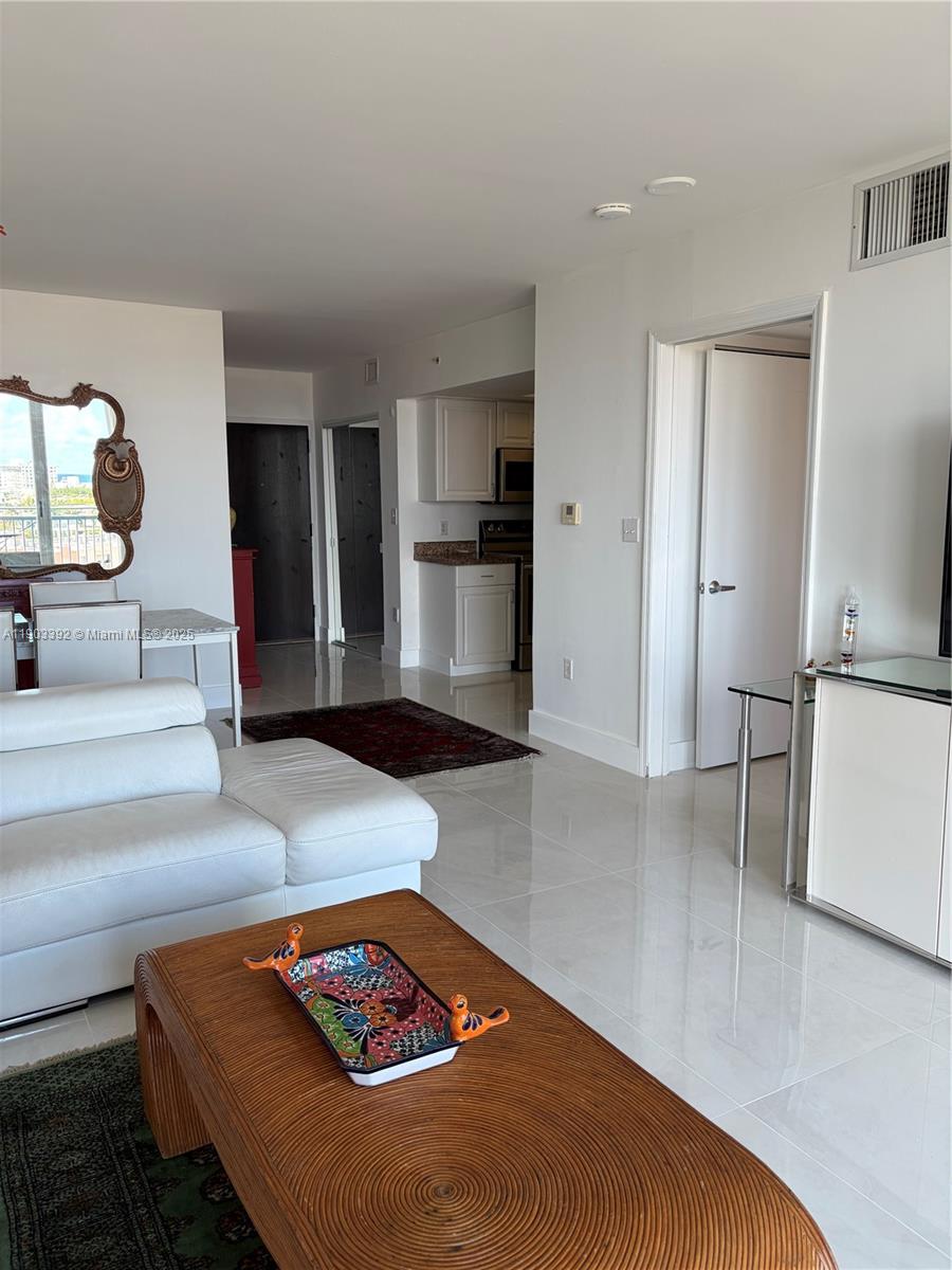 90 Alton Road, Unit 1007 Miami Beach, FL 33139 - Photo 5 of 16 a living room with furniture and a rug