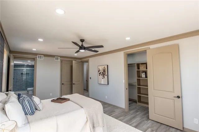 an empty room with wooden floor fan and windows