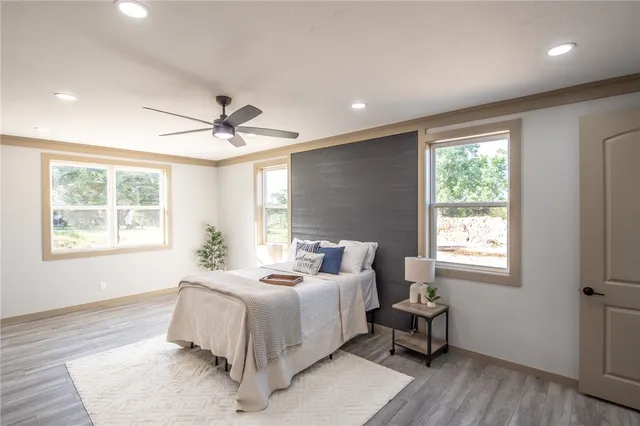 a spacious bedroom with a bed and wooden floor