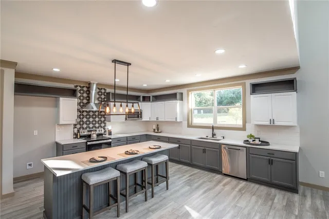 a kitchen with a sink a center island cabinets and a window