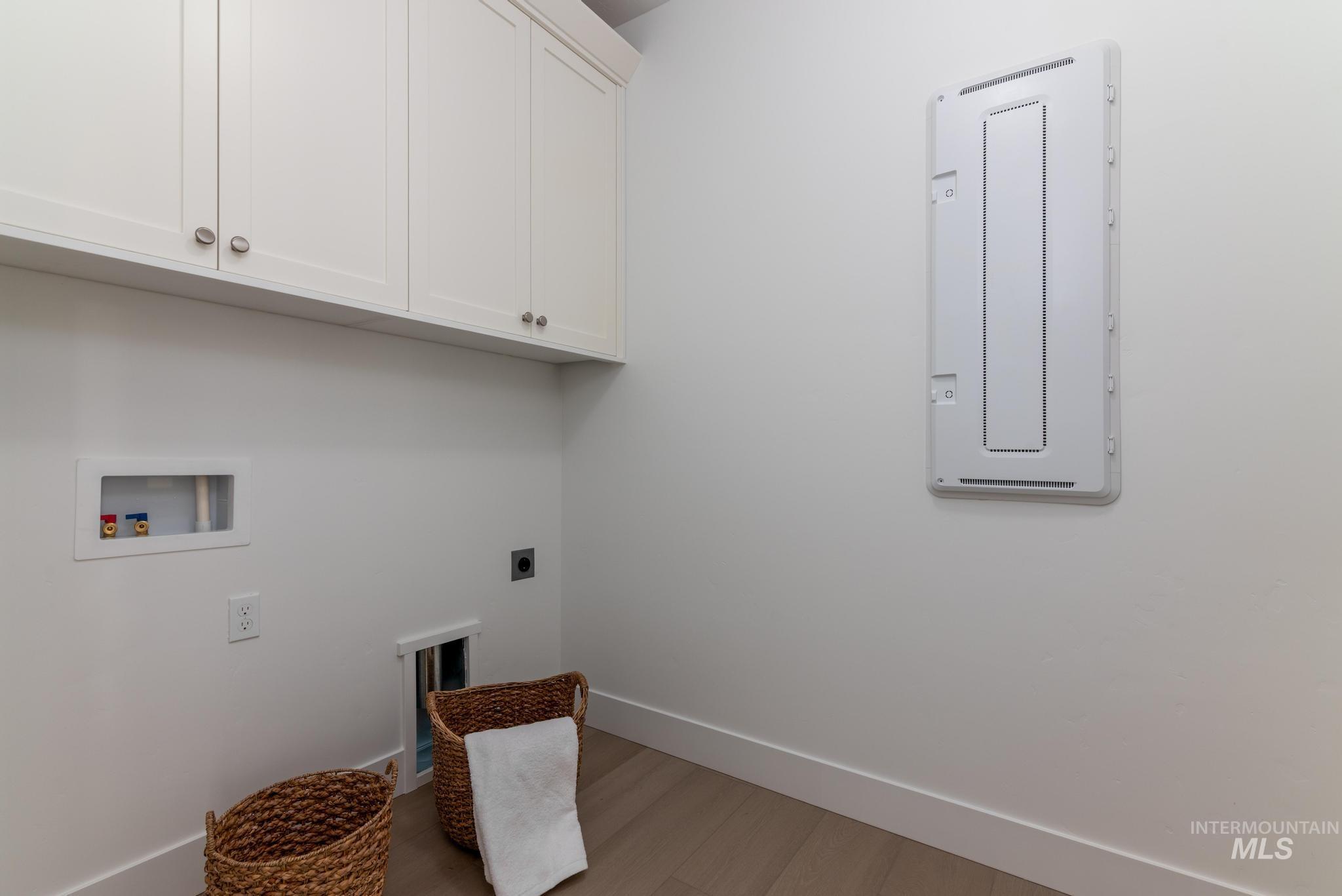 5431 North Ebony Way Meridian, ID 83646 - Photo 11 of 13 Laundry area with light wood-style flooring, hookup for a washing machine, cabinet space, electric dryer hookup, and electric panel