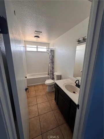 a bathroom with a sink a toilet a mirror and shower