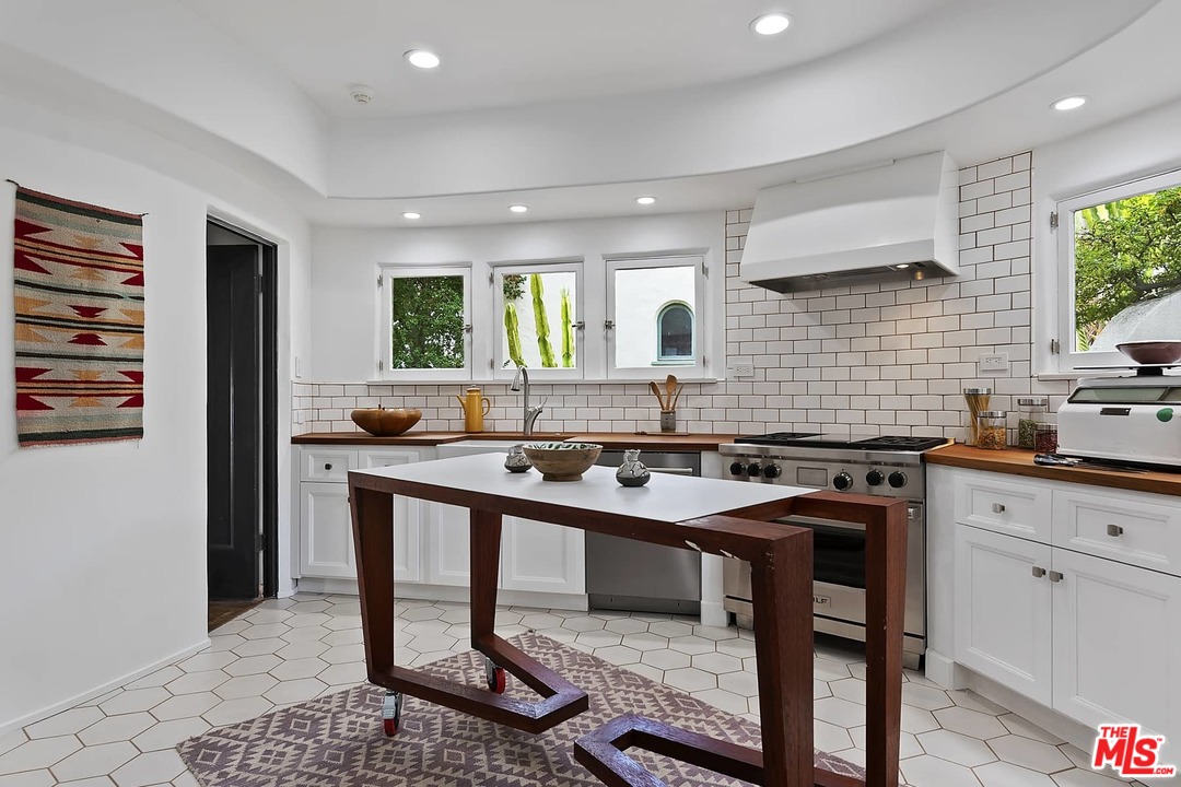 8142 Laurel View Drive Los Angeles, CA 90069 - Photo 16 of 41 a kitchen with stainless steel appliances granite countertop a sink a stove a refrigerator and cabinets