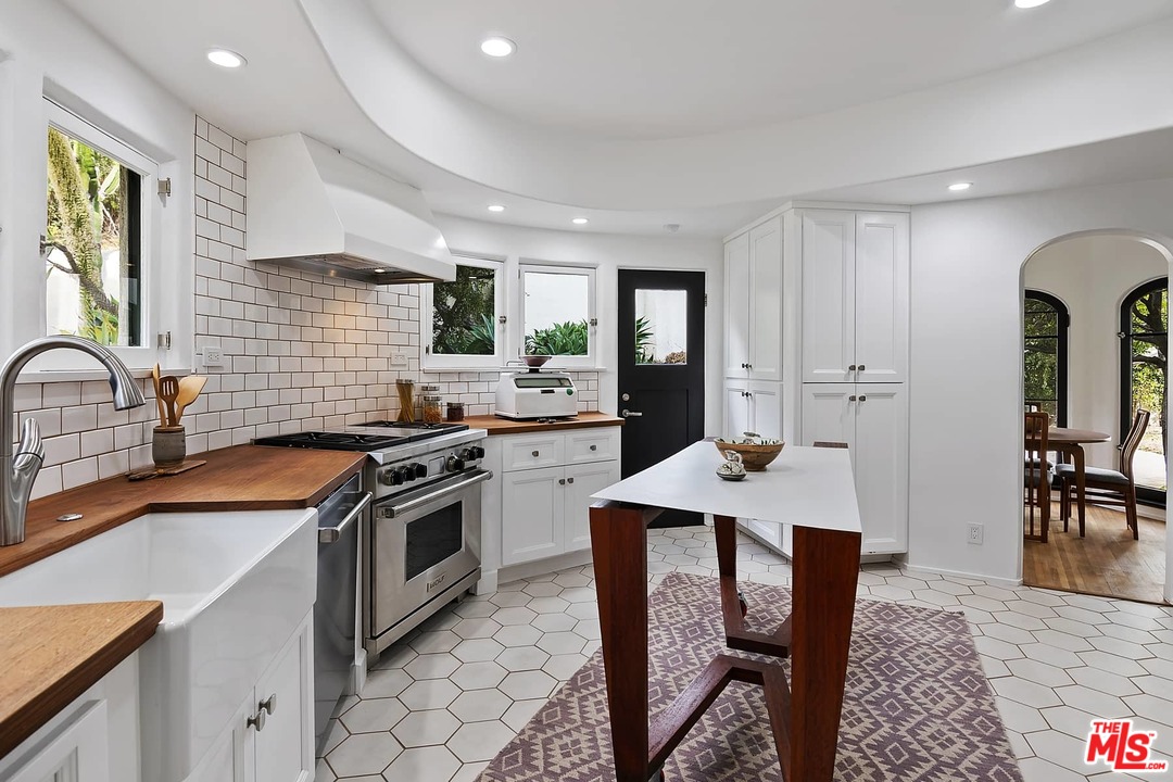 8142 Laurel View Drive Los Angeles, CA 90069 - Photo 18 of 41 a kitchen with stainless steel appliances granite countertop a stove a sink dishwasher a stove and a refrigerator with wooden floor