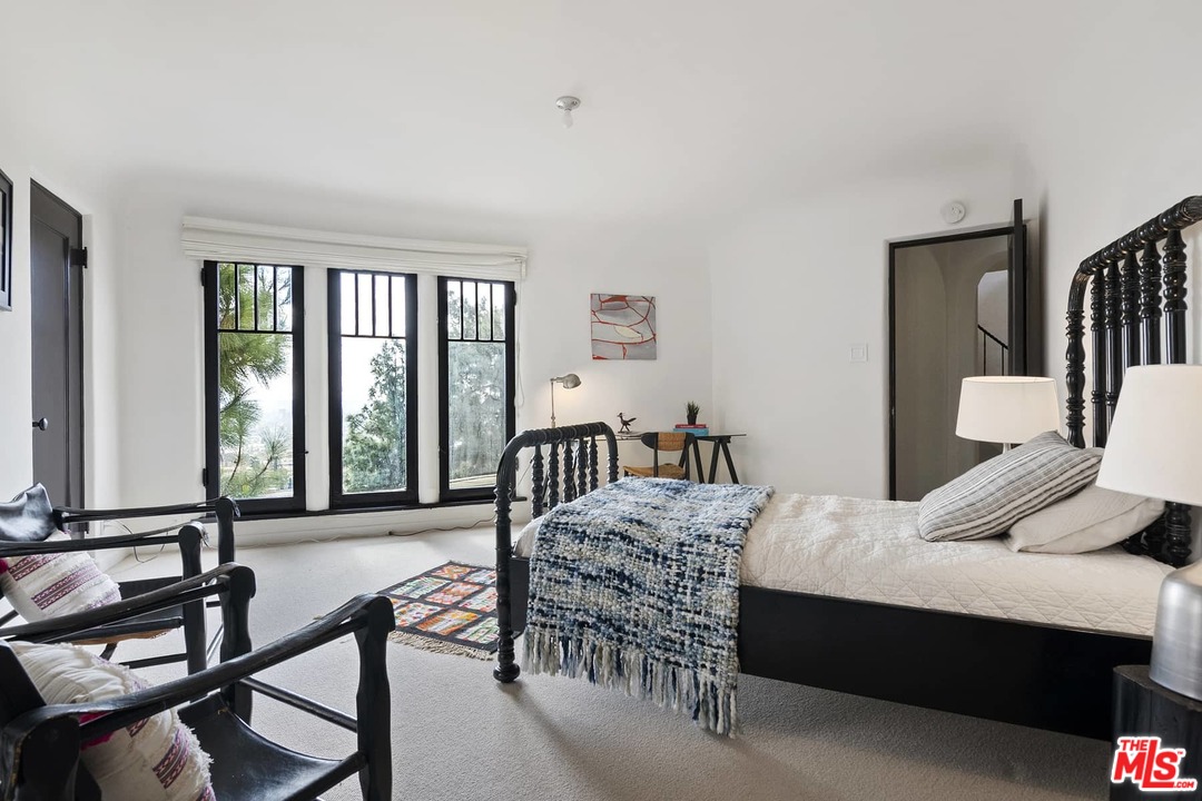8142 Laurel View Drive Los Angeles, CA 90069 - Photo 33 of 41 a bedroom with a bed a large window and furniture
