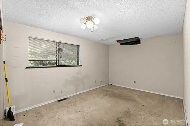 an empty room with closet and windows