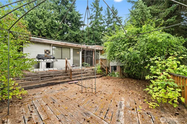 a view of a patio with table and chairs with wooden floor and fence