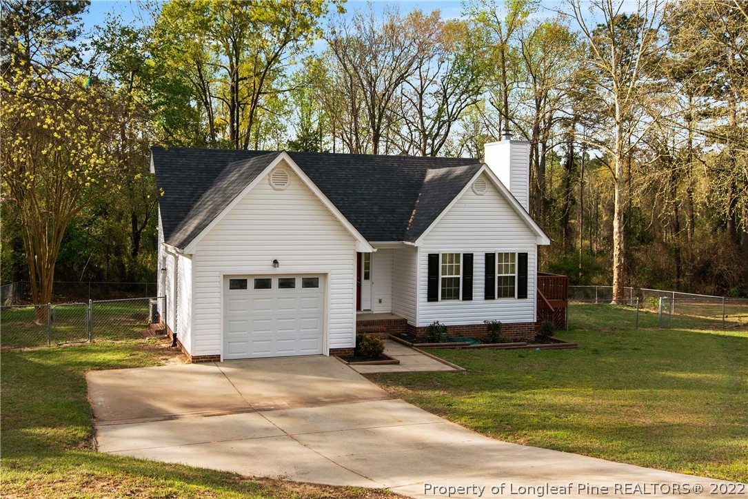 205 Rye Lane Raeford, NC 28376 - Photo 2 of 38 a view of a house with a yard plants and large tree