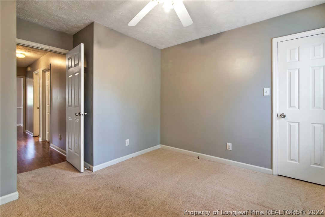 205 Rye Lane Raeford, NC 28376 - Photo 26 of 38 an empty room with wooden floor and a hallway