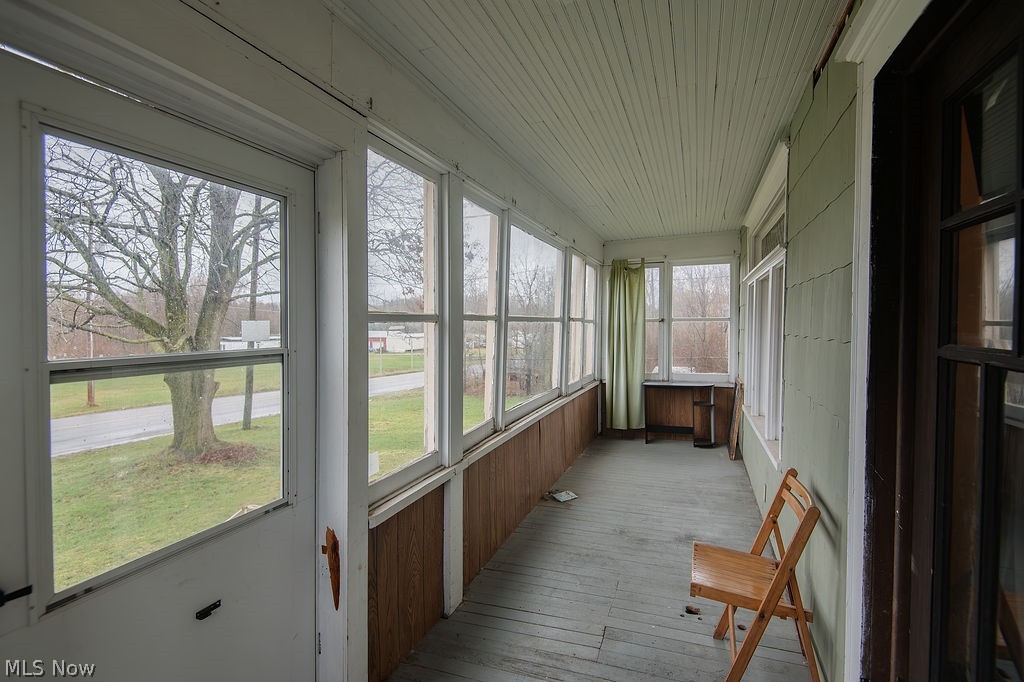 1195 South Johnson Road Sebring, OH 44672 - Photo 12 of 34 Unfurnished sunroom with wood ceiling, hardwood / wood-style flooring, and wood walls