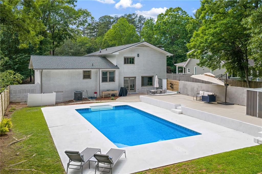 4205 South Berkeley Lake Road Northwest Berkeley Lake, GA 30096 - Photo 25 of 34 a view of house with swimming pool and chairs in front of house