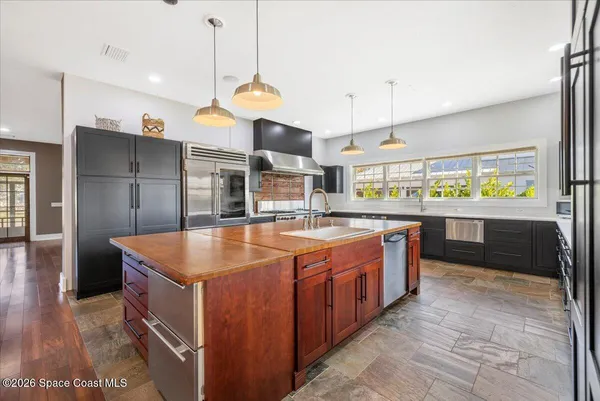 a open kitchen with stainless steel appliances granite countertop a refrigerator a sink dishwasher a stove and white countertops with wooden floor