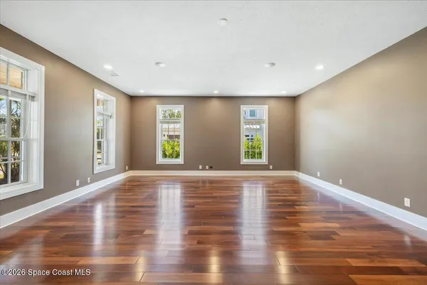 a living room with furniture pool table wooden floor and stairs