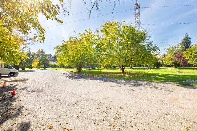 a front view of a house with a yard and potted plants
