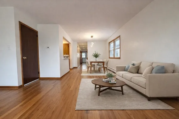 a living room with furniture and a wooden floor