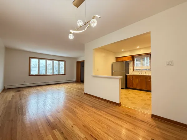 a view of a living room a kitchen and a wooden floor