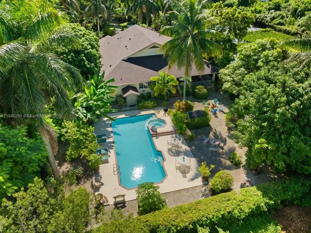 an aerial view of a house with yard swimming pool and outdoor seating