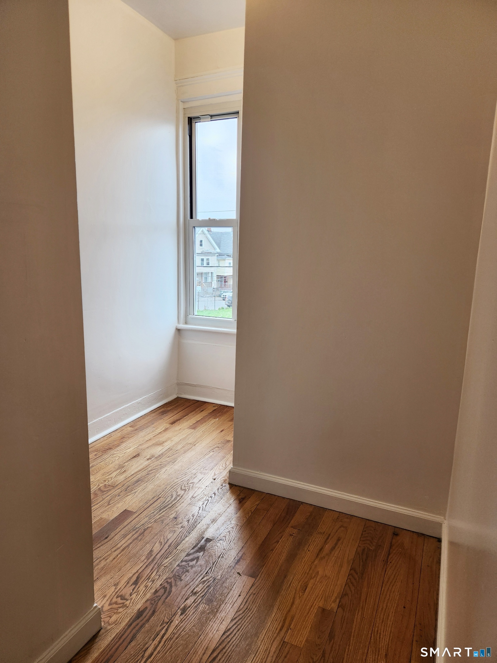 202 Harral Avenue, Unit B Bridgeport, CT 06604 - Photo 11 of 11 an empty room with wooden floor and windows
