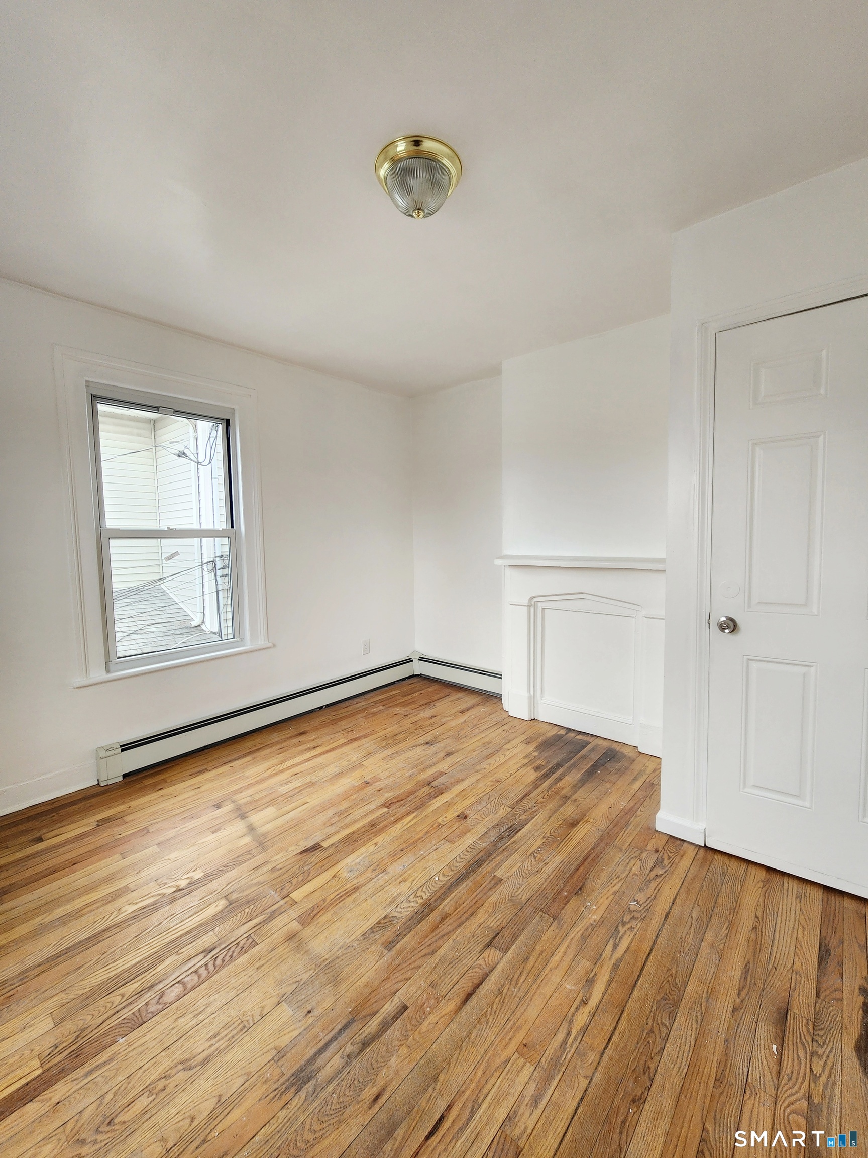 202 Harral Avenue, Unit B Bridgeport, CT 06604 - Photo 2 of 11 an empty room with wooden floor and windows