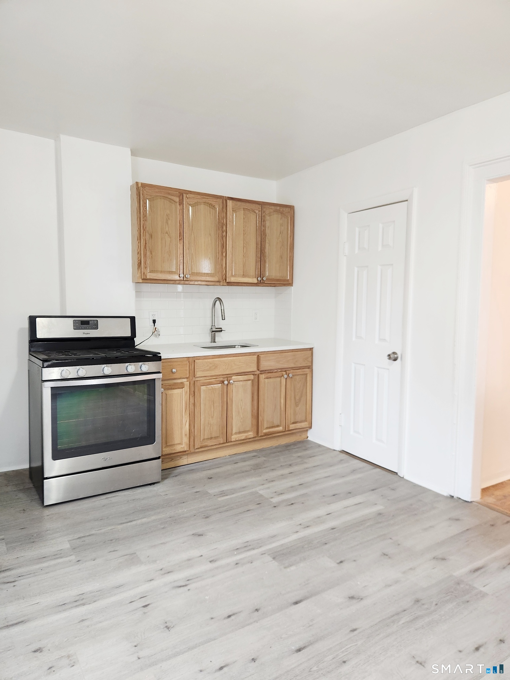 202 Harral Avenue, Unit B Bridgeport, CT 06604 - Photo 3 of 11 a view of a kitchen with a sink stove and cabinets