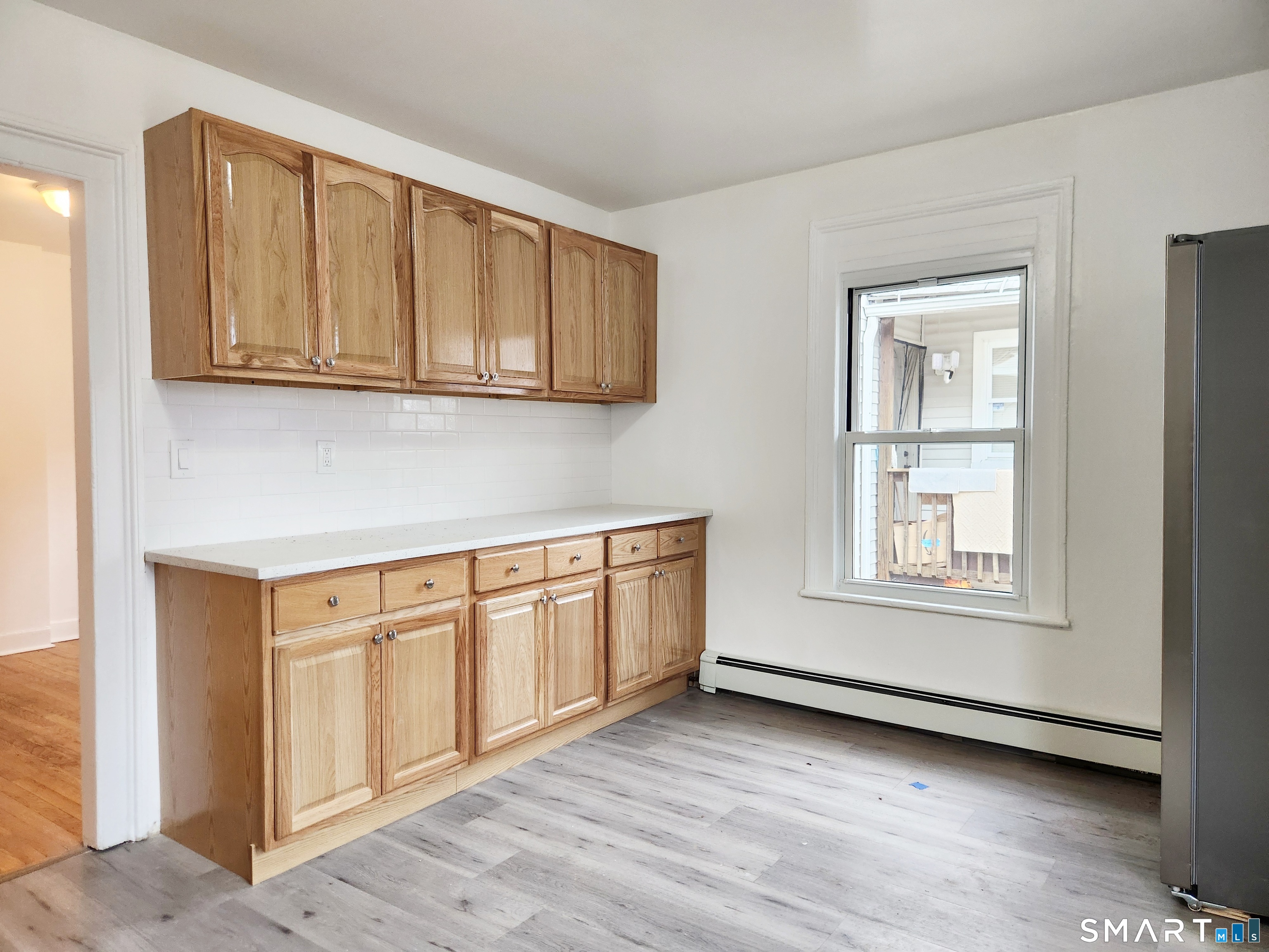 202 Harral Avenue, Unit B Bridgeport, CT 06604 - Photo 4 of 11 a view of an empty room with wooden floor and a window