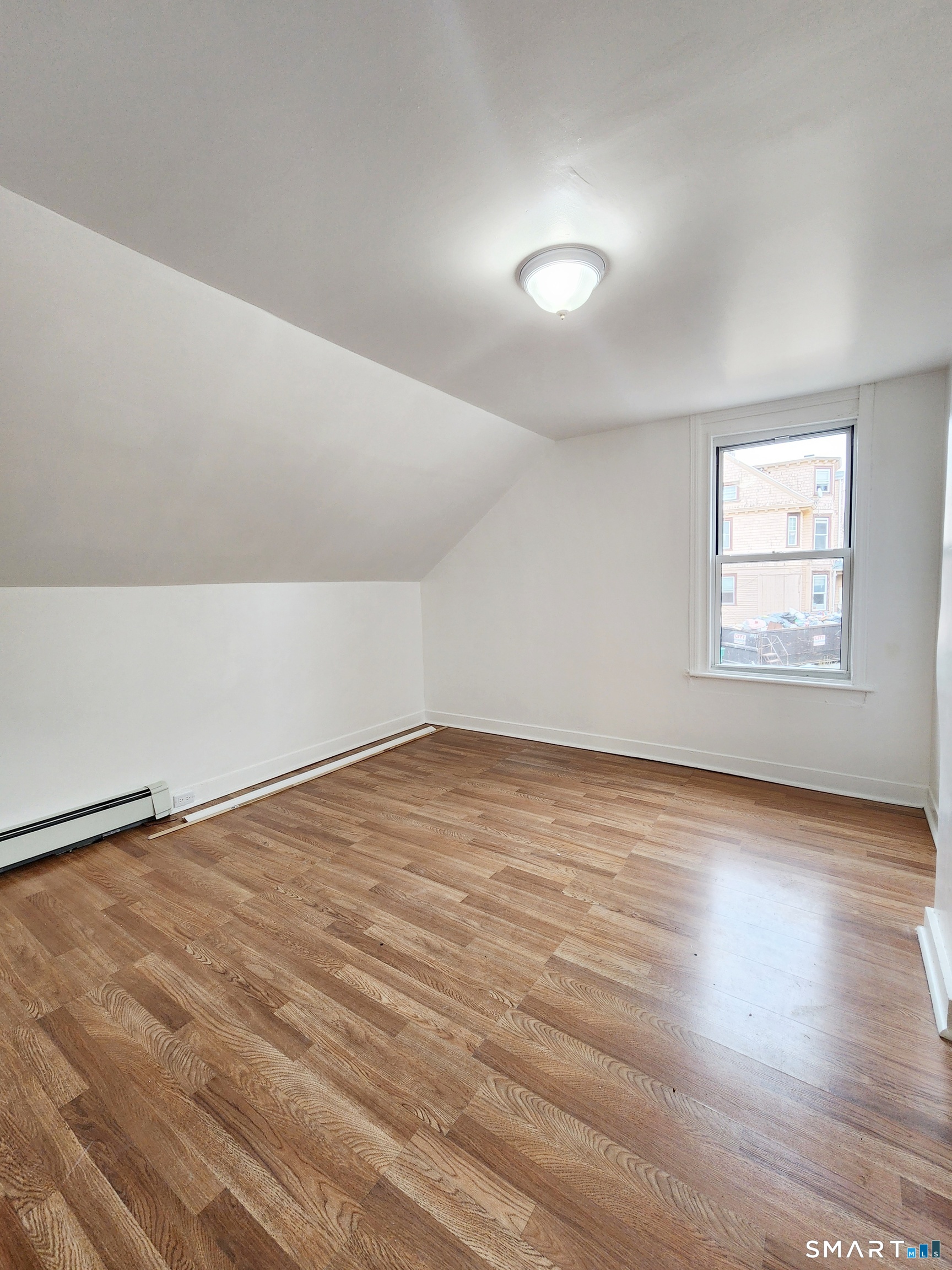 202 Harral Avenue, Unit B Bridgeport, CT 06604 - Photo 8 of 11 an empty room with wooden floor and windows