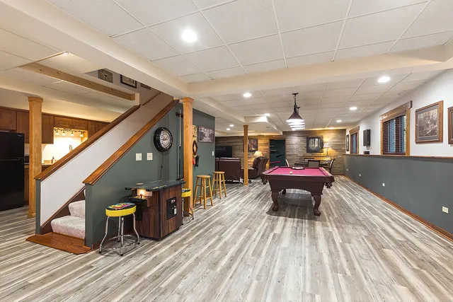 a kitchen with stainless steel appliances granite countertop a refrigerator a sink dishwasher a stove and white countertops with wooden floor