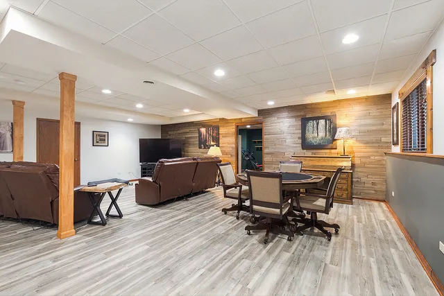 a kitchen with stainless steel appliances kitchen island granite countertop a table chairs sink and wooden floor