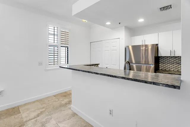 a kitchen with stainless steel appliances granite countertop a refrigerator and a sink