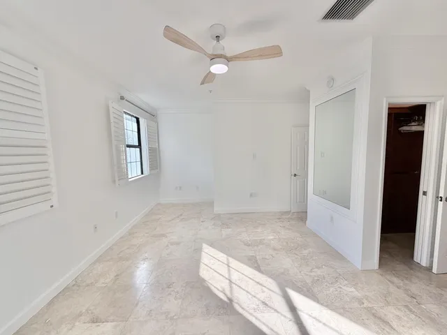 a view of a livingroom with a ceiling fan & a window